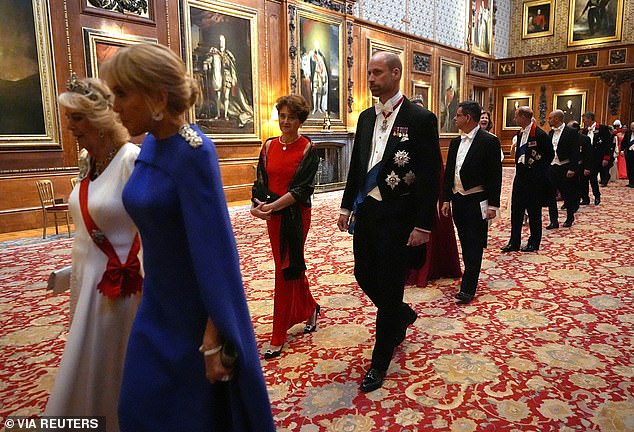Prince William walks into the banquet wearing white tie but not a Windsor uniform