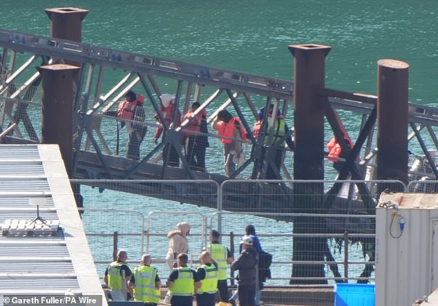 Today a group of people thought to be migrants are brought in to the Border Force compound in Dover, Kent, from a Border Force vessel following a small boat incident in the Channel