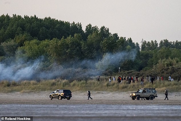 Police disperse a group of migrants waiting to board the small boat with tear gas at Gravelines