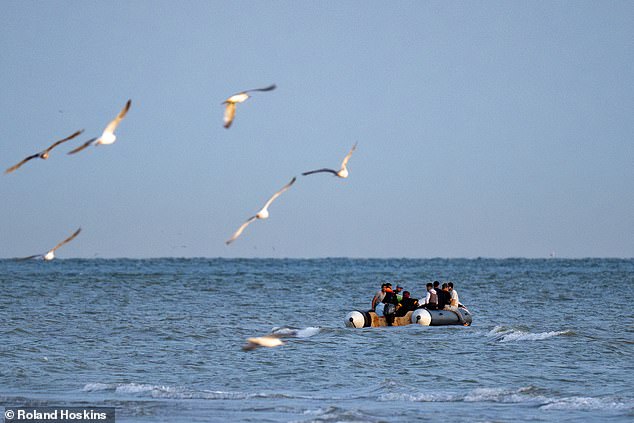 A migrant small boat passes the beech at Gravelines, France, today, before it is abandoned by passengers and punctured by police