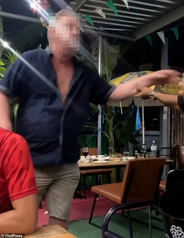 In one video captured earlier this year a drunk British husband (pictured) flew into a rage and yelled at a waiter at a restaurant in Thailand