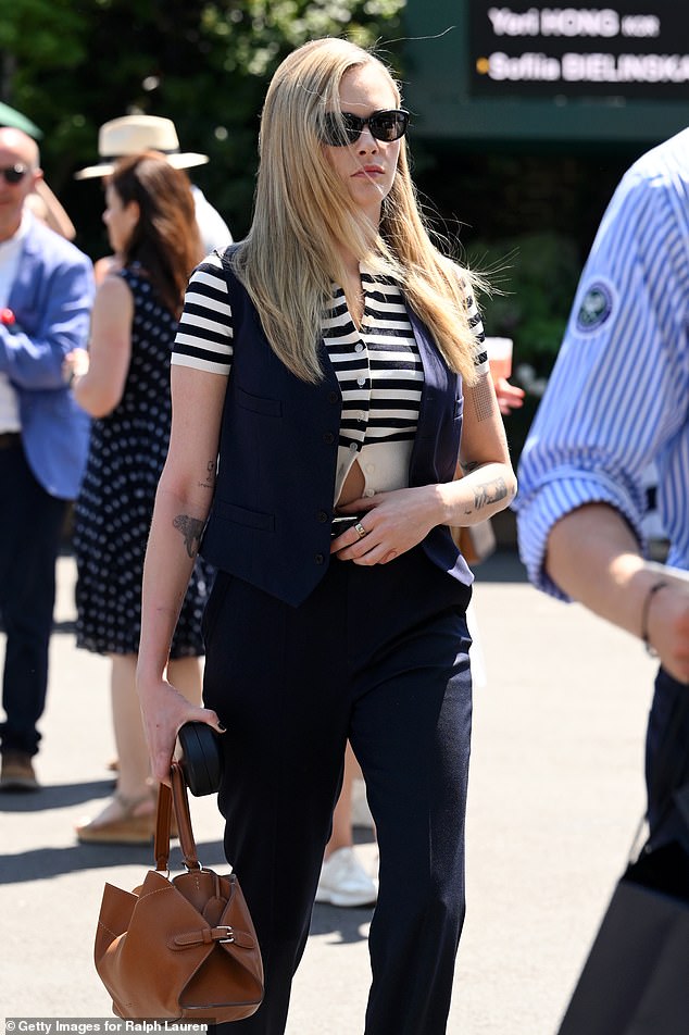Cara wore all Ralph Lauren as she put on a stylish display in smart navy trousers and a matching open waistcoat jacket