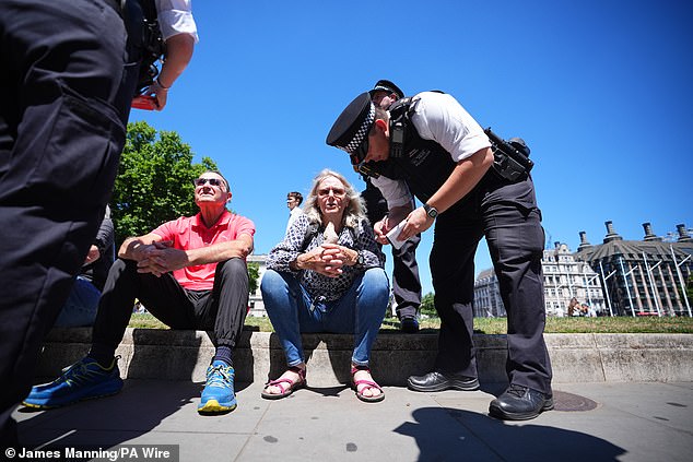 Police speak to people after they took part in a protest in Parliament Square, London
