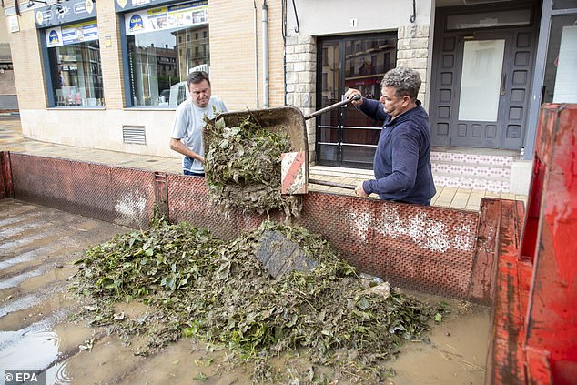 The downpour in Tarazona caused street flooding, heavy disruption to public transport and brutal damage to property in the getaway hotspot. Pictured: Residents remove leaves that clogged up drains after the heavy rain in Tarazona on Saturday