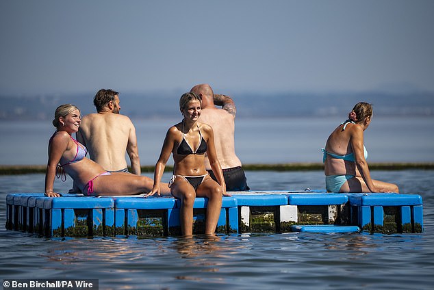 Six million homes have been hit with a hosepipe ban, while fire chiefs warn of the risk of wildfires and drowning as people try to escape the heat in pools and ponds. Pictured: Clevedon Marine Lake in Somerset on Friday