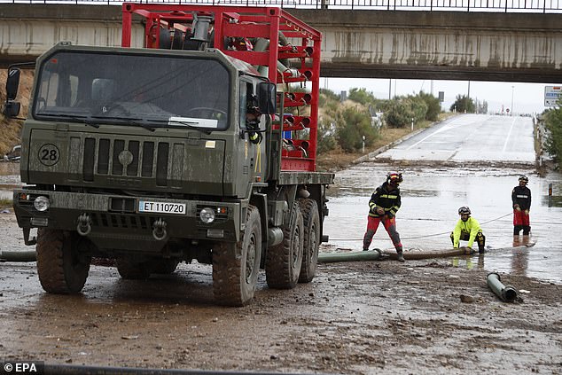 Rainfall of up to 50 litres per square metre has been predicted in most parts of Aragon and Catalonia - which could cause flooding and even overflowing ravines. Pictured: The UME work on a flooded road in Aragon on Saturday