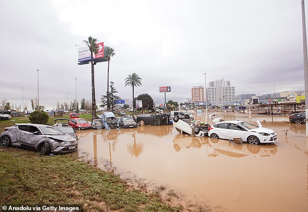 The floods turned streets in the Spanish city into rivers (pictured) and left hundreds trapped in their homes