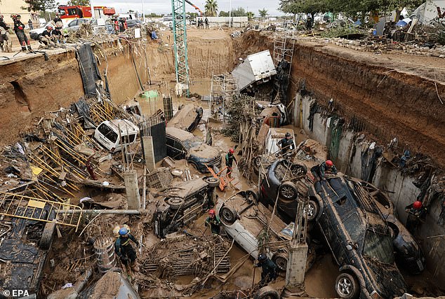 Many were forced to climb trees, scale lampposts and sprint desperately to the upper floors of buildings to escape. Pictured: Cars trapped under the foundations of a building under construction in Valencia during flooding there at the end of last year