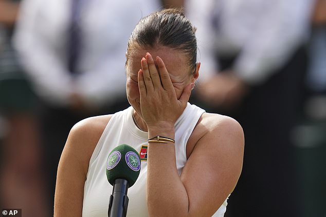 Anisimova puts her face in her hands after losing the singles final match against Iga Swiatek