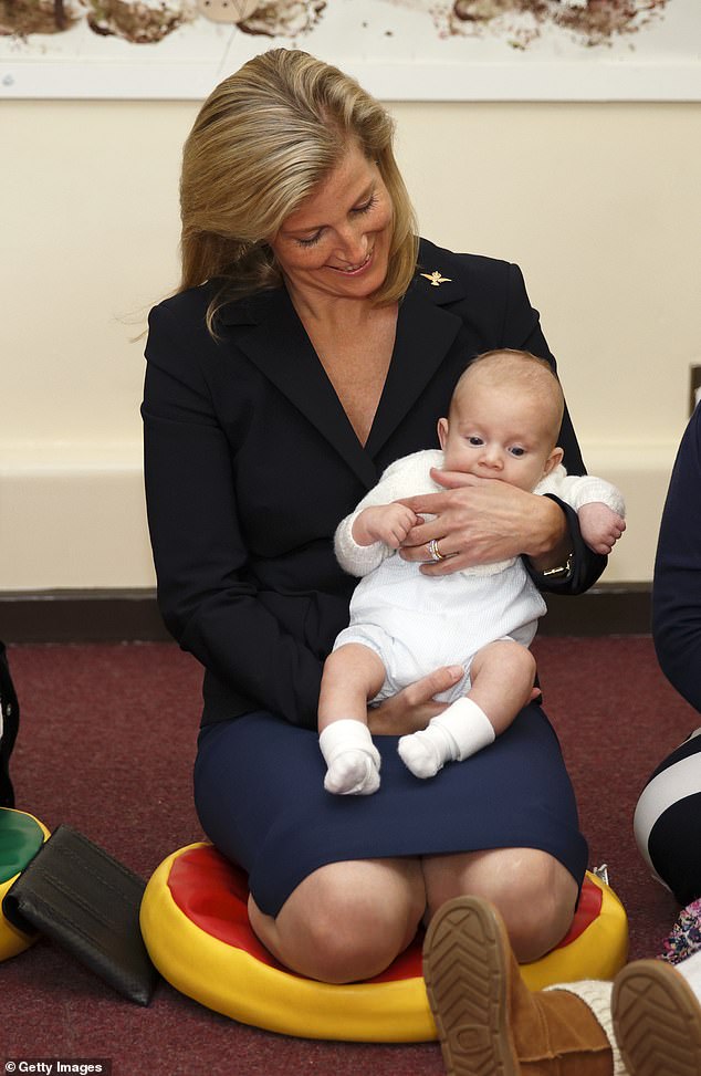 Sophie holds three month old Rowan Wilson-Jones as she attends a Musical Minis class during a visit to RAF Wittering on September 30, 2014