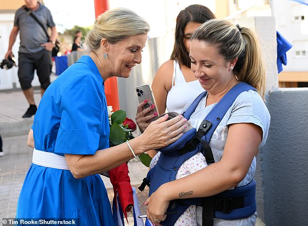 Duchess Sophie greets a baby during a walkabout of Main Street