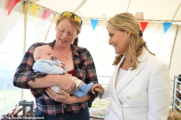 Sophie with a baby as she visits The Royal Agricultural Society Show Ground for their 'Education Day' in the Isle of Wight on May 24, 2022
