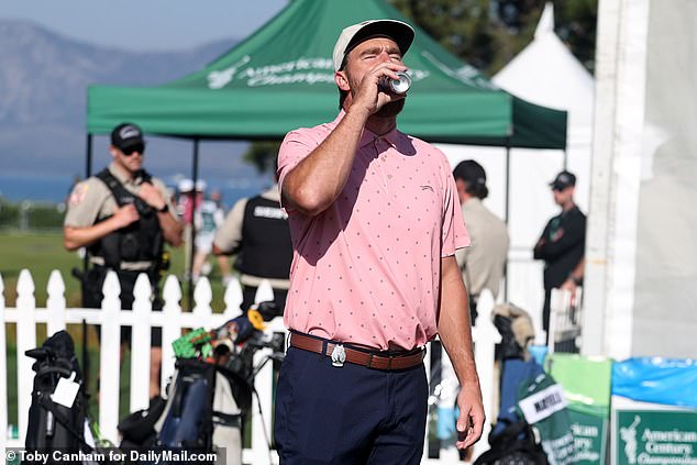 The tight end,sporting a pink polo from Tiger Woods' Sun Day Red, sips an energy drink
