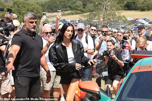 The Albanian-British star is seen stepping out of the Porsche at Goodwood on Saturday