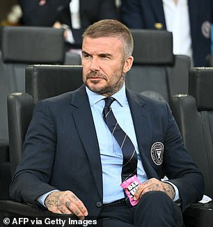 David, 50, cut a dapper figure in a navy suit, teamed with a blue shirt and matching tie as he proudly watched his team