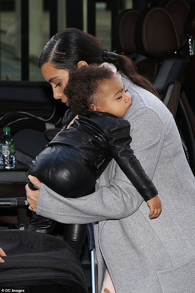 A few moments later the Kardashian's star re-emerged with North while making her way through flashing cameras back to the waiting SUV, which was due to whisk them to the airport