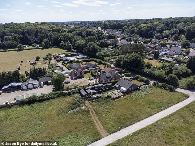 The new two-bedroom home (centre) is now a picture postcard cottage on the back lawn