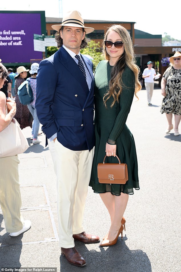 Completing his look with a polka dot tie and a straw fedora, the Superman star beamed as he posed with his girlfriend Natalie Viscuso, who looked stylish a forest green midi dress