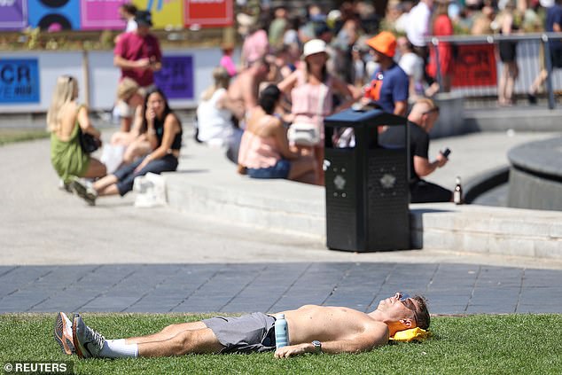 MANCHESTER: A man sunbathes on the grass at Piccadilly Gardens on July 12, 2025