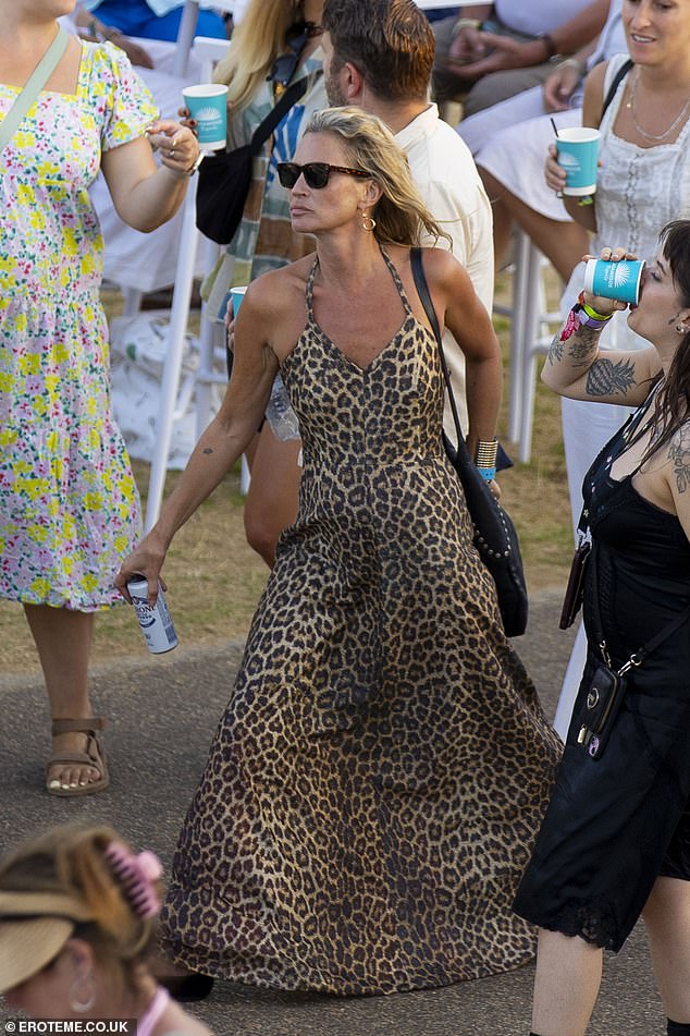 The supermodel, 51, looked typically stylish in a plunging leopard print maxi dress and sandals