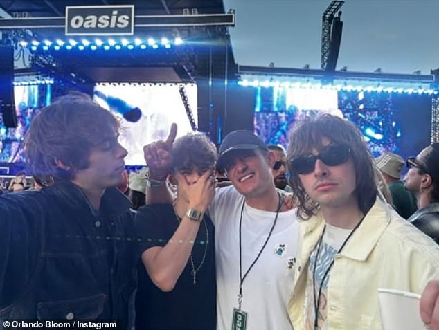 Orlando looked thrilled to be partying with the Oasis stars children including Liam's sons Lennon, 25, (R) and Gene, 24 (L)