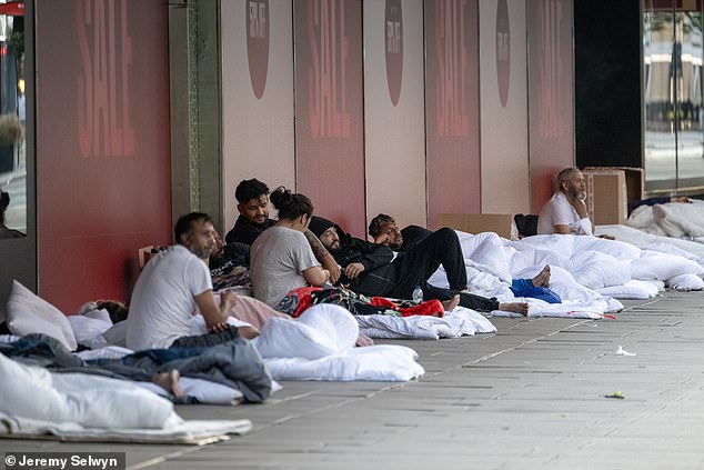 The group, which set up camp outside the shopping destination's John Lewis , were seen in a line sitting on their duvets as they rested and smoked cigarettes this morning