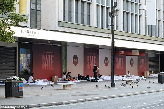 Migrants sleeping in new white duvets outside John Lewis on London's Oxford Street today