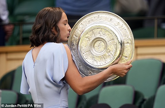 Ladies' Singles champion Iga Swiatek with the Venus Rosewater Dish, in the Royal Box on day fourteen of the 2025 Wimbledon Championships at the All England Lawn Tennis and Croquet Club, London. Picture date: Sunday July 13, 2025. PA Photo. Photo credit should read: Jordan Pettitt/PA Wire.RESTRICTIONS: Editorial use only. No commercial use without prior written consent of the AELTC. Still image use only - no moving images to emulate broadcast. No superimposing or removal of sponsor/ad logos.