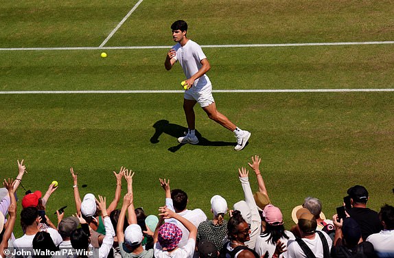 Carlos Alcaraz throws balls into the crowds following a practice session on day fourteen of the 2025 Wimbledon Championships at the All England Lawn Tennis and Croquet Club, London. Picture date: Sunday July 13, 2025. PA Photo. Photo credit should read: John Walton/PA Wire.RESTRICTIONS: Editorial use only. No commercial use without prior written consent of the AELTC. Still image use only - no moving images to emulate broadcast. No superimposing or removal of sponsor/ad logos.