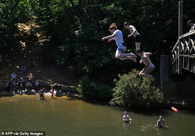 Teenagers cool off by leaping into the River Wey, near Guildford, on July 13, 2025