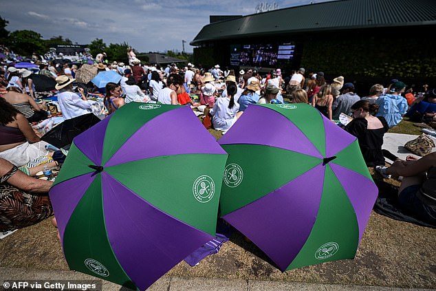 WIMBLEDON: Tennis fans propped up their branded umbrellas outside Court One on Henman Hill on the last day of the 2025 Championships