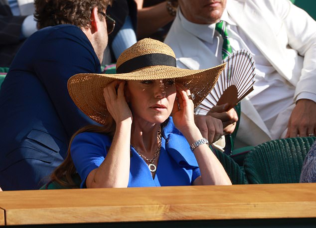 Catherine, Princess of Wales, wearing a stylish hat, watches the third set of the tightly-fought final