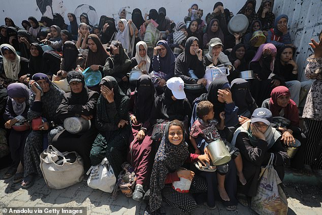 A charity organization distribute hot meals to Palestinians facing difficulties in accessing food due to Israel's ongoing attacks on the Gaza Strip
