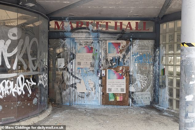 The front door of the Swindon's market, which has been closed for eight years, is covered in graffiti