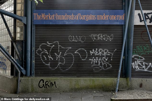 A slogan on the side of the market promises 'hundreds of bargains under one roof' but the premises remain closed