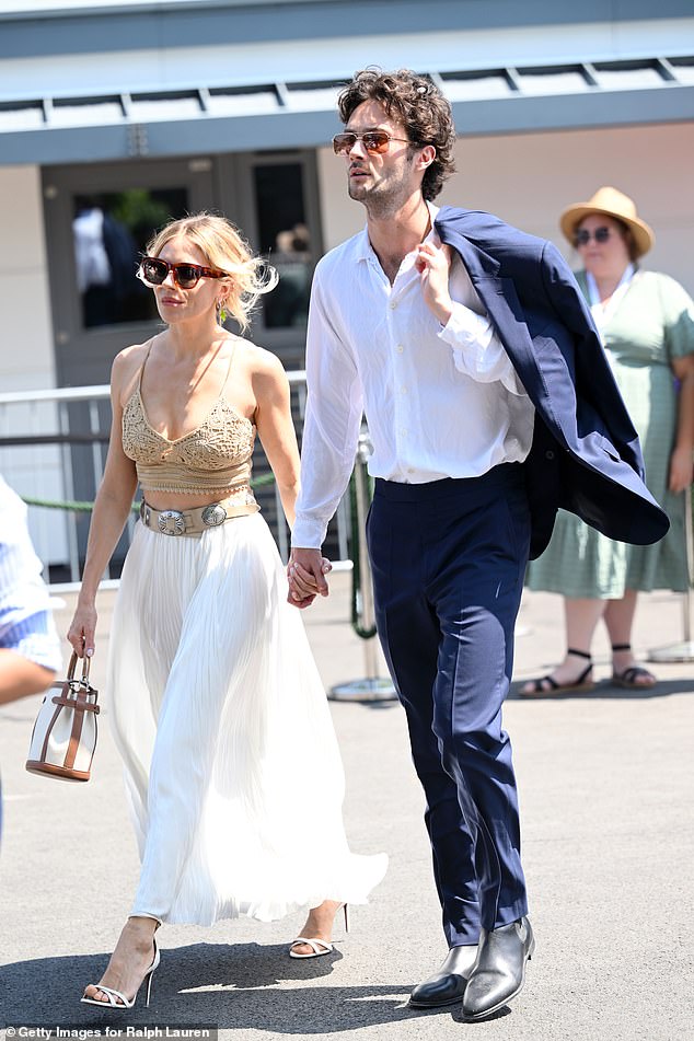 While her actor boyfriend Oli, looked dashing in a tailored navy blue suit over a white button-up shirt and leather boots