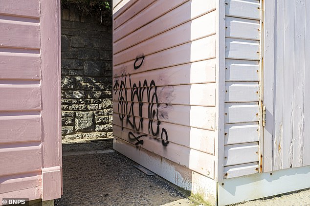 Graffiti etched on the side of one beach hut two months ago