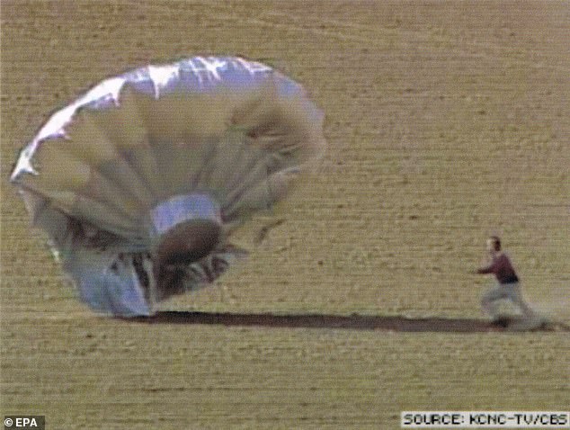 On October 15, 2009, the silver helium balloon - shaped like a flying saucer - drifted up to 7,000 feet across the Colorado sky. Pictured: A law enforcement officer running toward the home-built helium filled balloon as it landed near the Denver, Colorado, airport