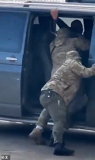 He grabs onto the frame of the car in a last ditch attempt to save himself