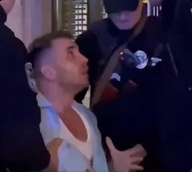 A distraught man appears to plead with conscription officers as they surround him in Kyiv