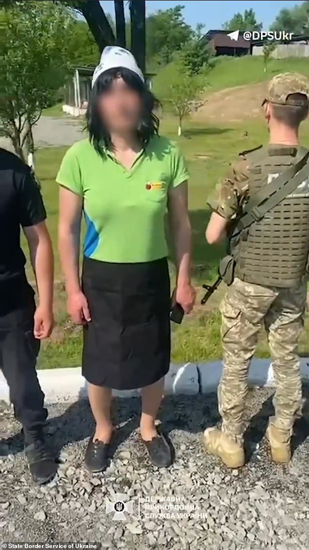 The man who dressed as a woman in an attempt to flee the country is detained by armed officers