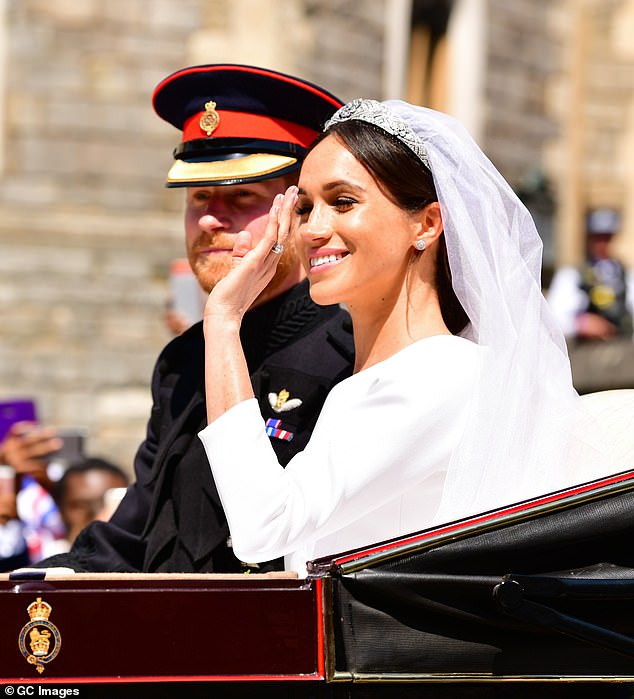 Prince Harry and Meghan wave from their carriage at their wedding in May 2018