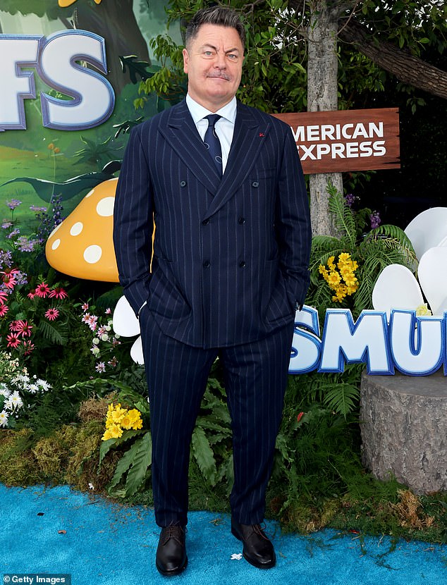 Nick Offerman dressed for the occasion wearing a dark navy, pin-striped suit that comprised of slacks and double-breasted blazer