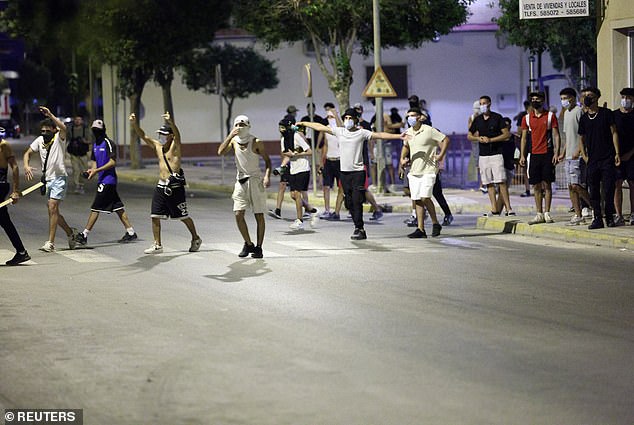 Masked young men are seen gathering in the street on Saturday night