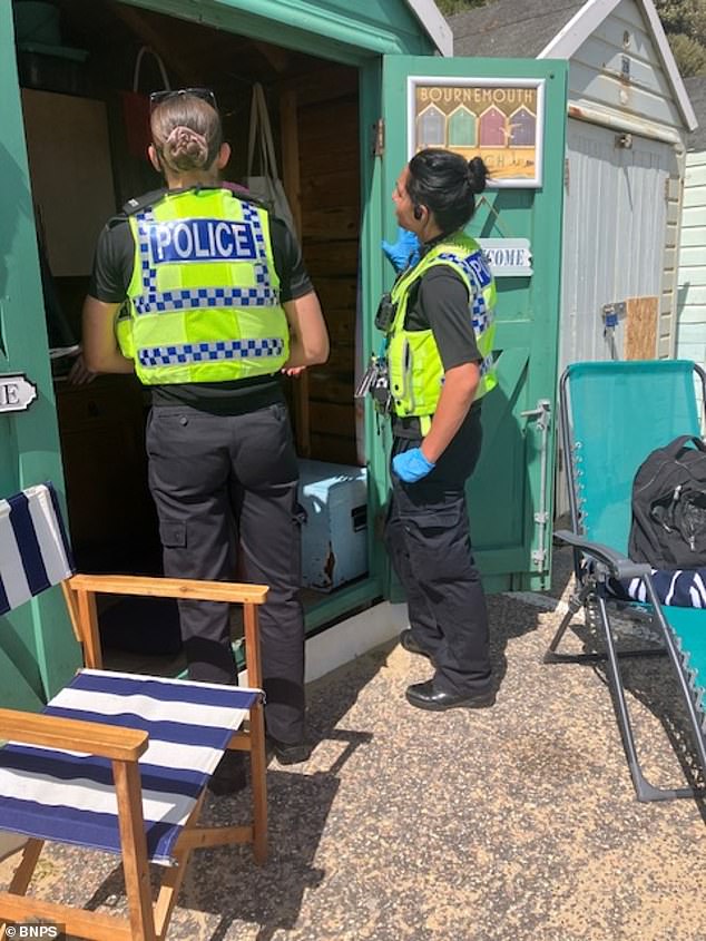 Police are pictured at the scene of the Davies' beach hut following the alleged attack