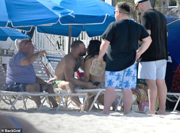 He packed on the PDA with the bikini-clad woman as they smooched in full view of other beachgoers