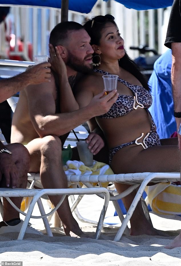 He was spotted enjoying a cold beverage while the woman, who was dressed in a racy leopard print bikini, shared his sun lounger
