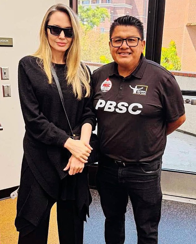 Angelina, 50, proudly posed with one of the coaches at the event