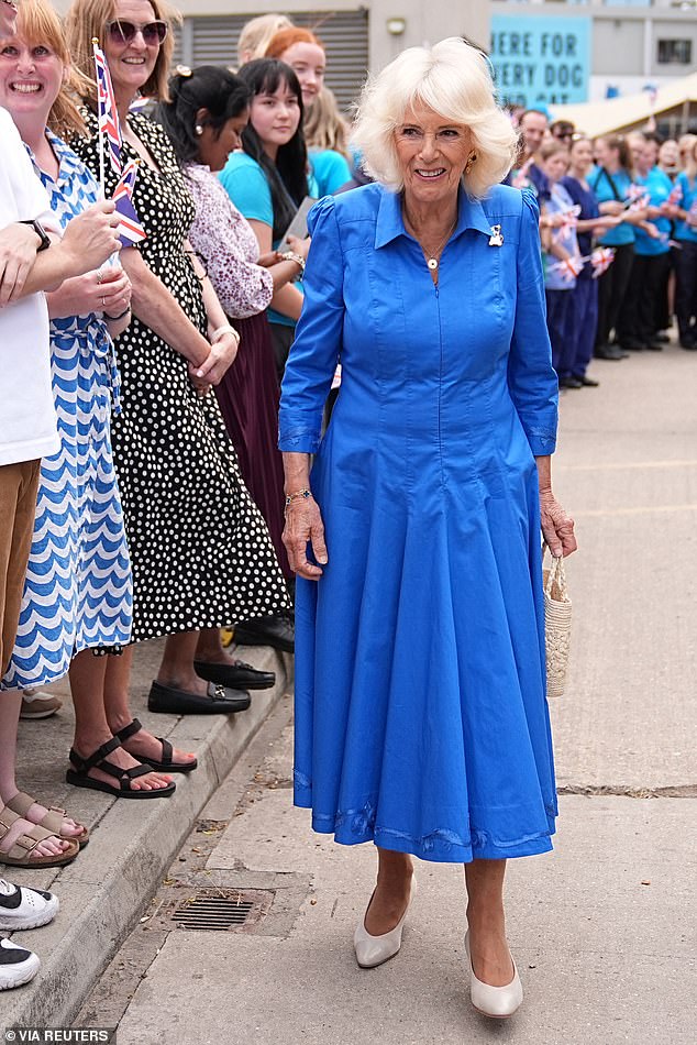 Camilla is pictured in a stylish royal blue dress as she visits Battersea Dogs' and Cats' Home on Monday