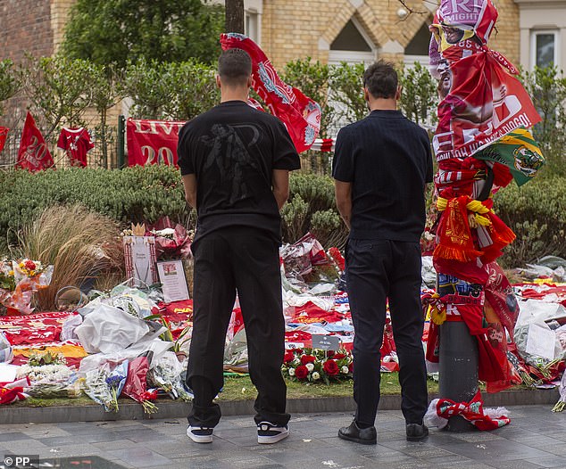 Fernandes and Dalot were pictured standing with their heads bowed in front of the tributes